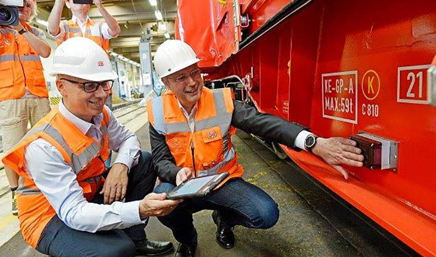 Marek Staszek, miembro del Consejo de Administraci&oacute;n de Producci&oacute;n en DB Cargo (izquierda) y J&uuml;rgen Harland, jefe de Log&iacute;stica y SCM en Salzgitter Flachstahl GmbH, activan el m&oacute;dulo telem&aacute;tico en uno de los vagones.