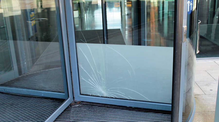 Cristal roto desde hace semanas en la puerta de acceso al edificio. Foto JMR.