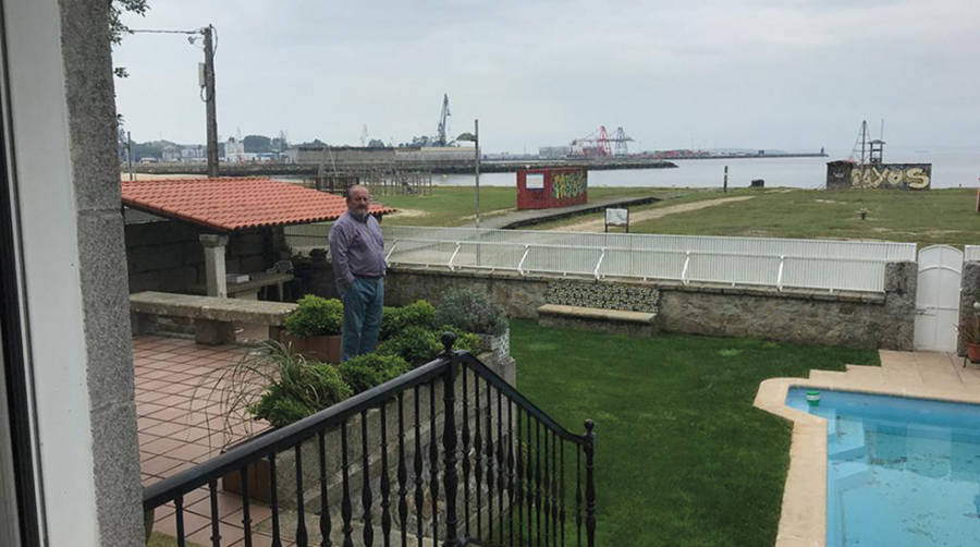 Julio Carrasco, en el jard&iacute;n de su casa con el puerto de Vilagarc&iacute;a en el horizonte.