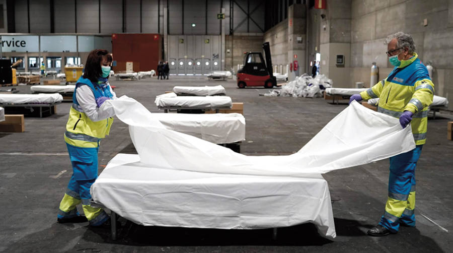 Dos trabajadores en la instalaci&oacute;n del hospital provisional de Ifema.